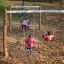Kinder spielen auf einer Doppel Schaukel Robinie im Herbstpark.