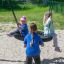 Kinder spielen auf einer Nestschaukel Robinie im Park.