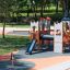 Spielplatz mit Spinner I, Kind spielt an drehbarem Klettergerät aus Holz und Kunststoff.