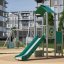 Aussichtspunkt mit Rutsche auf modernem Spielplatz in Wohnanlage