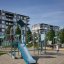 Spielanlage Köln mit blauem Rutschelement und Kletterstrukturen auf urbanem Spielplatz