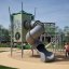 Kletterturm mit Spiralrutsche Alpha Centauri auf dem Spielplatz.