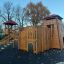 Spielanlage Skandinavische Hochburg aus Holz mit Rutsche und Klettergerüst auf Spielplatz bei klarem