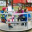 Kinder spielen auf einem Karussell im Freien auf einem Spielplatz.