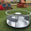 Karussell für Kinder auf einem Spielplatz mit grünem Kunstrasen.