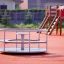 Karussell auf einem Spielplatz, umgeben von anderen Spielgeräten.