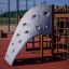 Aztek Spielanlage mit Kletterwand und Rutsche auf einem Spielplatz.