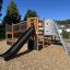 Aztek Spielanlage mit Kletterwand und Rutsche auf einem Spielplatz.