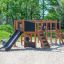 Klettergerüst mit Rutsche und Kletternetz auf einem Kinderspielplatz.