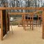 Holzspielplatz Düsseldorf mit Kletterwand, Tunnel und Rutschen im Freien.