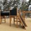 Düsseldorf Spielanlage mit Kletterwand, Tunnel und Rutsche auf einem Spielplatz.