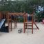 Kinderspielplatz Bonn Spielanlage mit Rutsche im Sandpark mit Kindern im Hintergrund