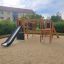 Bonn Spielanlage mit Rutsche auf einem Kinderspielplatz in sandiger Umgebung.