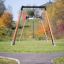 Drahtseilbahn Mittel im Park auf grünem Rasen mit Herbstbäumen im Hintergrund.