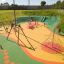 Kinder spielen auf einem bunten Spielplatz mit Drahtseilbahn Mittel und verschiedenen Klettermöglich