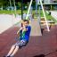 Junge spielt auf einer Seilbahn aus Metall auf einem Spielplatz.
