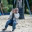 Seilbahn aus Metal auf einem Spielplatz mit sandigem Boden.