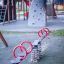 Doppelte Wippe auf einem Kinderspielplatz mit Klettergerüst im Hintergrund.