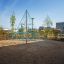 Spinnennetz-Kletternetz auf einem Spielplatz mit Sandboden im urbanen Park.