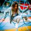 Mädchen spielt auf einem blauen Spinnennetz Kletternetz auf einem Spielplatz.