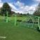 Kletterspielplatz mit Balancier Spielplatz Netz und bunten Kletterstrukturen auf grünem Rasen.