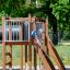Kind auf Holzspielgerät Tarzan Klettergerüst mit Tunnel im Freien.