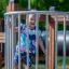Kleinkind spielt auf Tarzan Klettergerüst mit Tunnel auf Spielplatz.