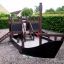 Kleines Schiff Sandkasten mit Rutsche für Kinder im Garten.