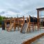 Holz-Spielplatz Piraten Basis mit Rutsche, Tunnel und Kletterelementen, auf Kieseluntergrund.