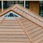 Langes Feuerhaus aus Holz mit Schindeldach auf dem Spielplatz.