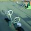 Grünes Wippe-Spielgerät auf einem Spielplatz.