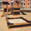 Kinder-Sandkasten und Spielhaus mit Rutsche auf einem Spielplatz in urbaner Umgebung.