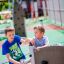 Zwei Kinder spielen an der Versteckte Ecke Kletterwand mit Kletternetz auf dem Spielplatz.