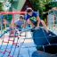 Zwei Kinder spielen auf dem Klettergerüst Kleiner Bergsteiger auf einem bunten Spielplatz.