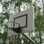Outdoor-Basketballkorb in einem Park mit Bäumen im Hintergrund.