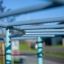 Nahaufnahme der blau-grünen Metallstruktur von Delphin Kletteranlage mit Fokussierung auf Regentropf
