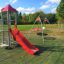 Grashüpfer Spielturm mit Rutsche und Schaukeln auf einem Spielplatz
