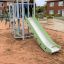 Maikäfer Spielturm mit Kletterwand und Rutsche auf einem Spielplatz