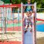 Kinder spielen auf Spielanlage Walfisch mit Rutsche und Kletternetz auf Spielplatz.