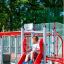 Kind auf Hai Klettergerüst mit Rutsche auf einem Spielplatz.