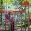 Kinder spielen auf einem Schmetterling Kletterturm mit Rutsche auf einem Spielplatz.