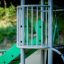 Kinderspielgerät Schmetterling Kletterturm mit Rutsche in einem Park.