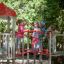 Kinder spielen auf einem Spinne Kletterturm mit Rutsche auf einem Spielplatz.