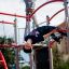 Kinder spielen auf Spinne Kletterturm mit Rutsche auf Spielplatz.