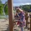 Mädchen spielt auf Alv Klettergerüst mit Rutsche und Kletternetz auf einem Spielplatz.
