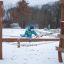 Kind spielend auf Alv Klettergerüst mit Rutsche und Kletternetz im Winter.