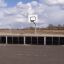 Junge spielt Basketball auf Stamford Bridge Multisport-Anlage mit Outdoor-Basketballkorb.