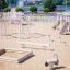 Alstad Spielkombination mit Rutsche auf einem sandigen Spielplatz.