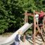 Kleines Kind spielt auf Bergila Spielkombination mit Rutsche im Park.
