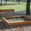 Sandkasten aus Lärchenholz mit verzinktem Stahl im Park.